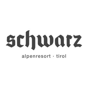 Logo des Schwarz Alpenresort Tirol in altdeutscher Schrift auf weißem Hintergrund.