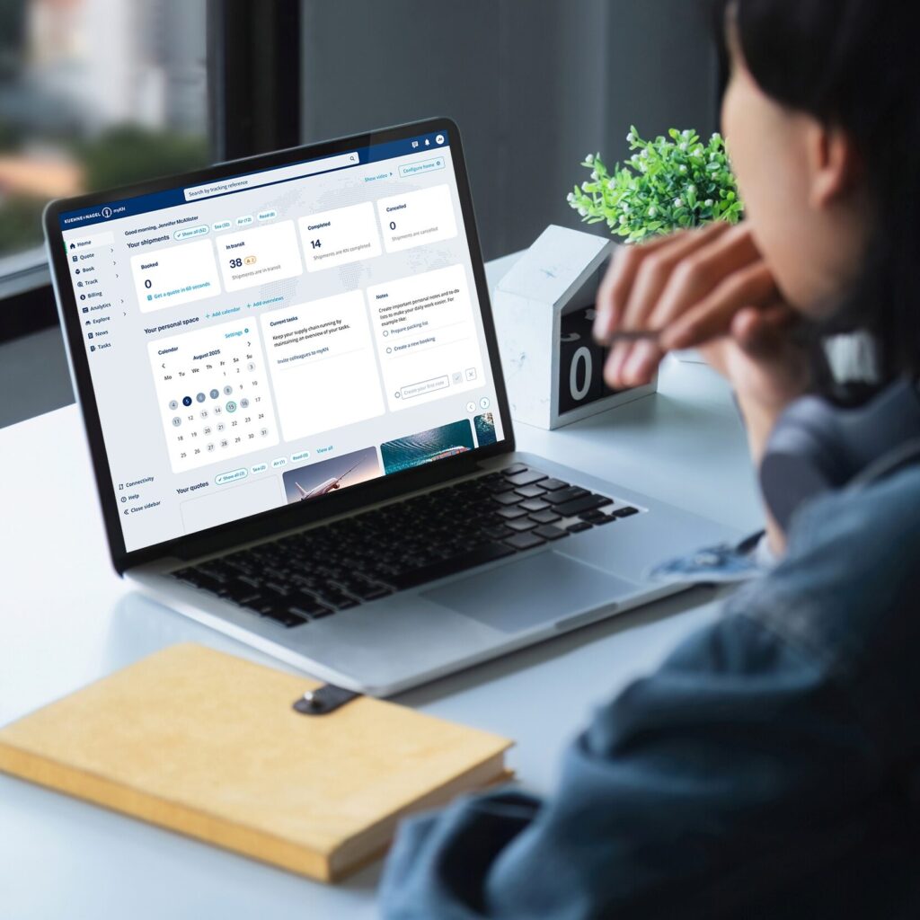 Eine Person sitzt am Schreibtisch und betrachtet ein Logistik-Dashboard auf dem Laptop.