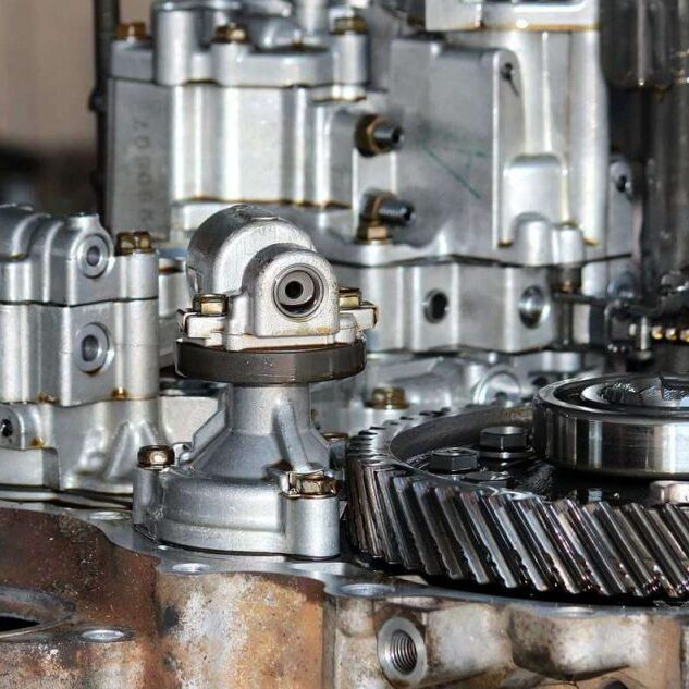 Komplexe mechanische Metallbauteile und ein Zahnrad in einem geöffneten Fahrzeuggetriebe.