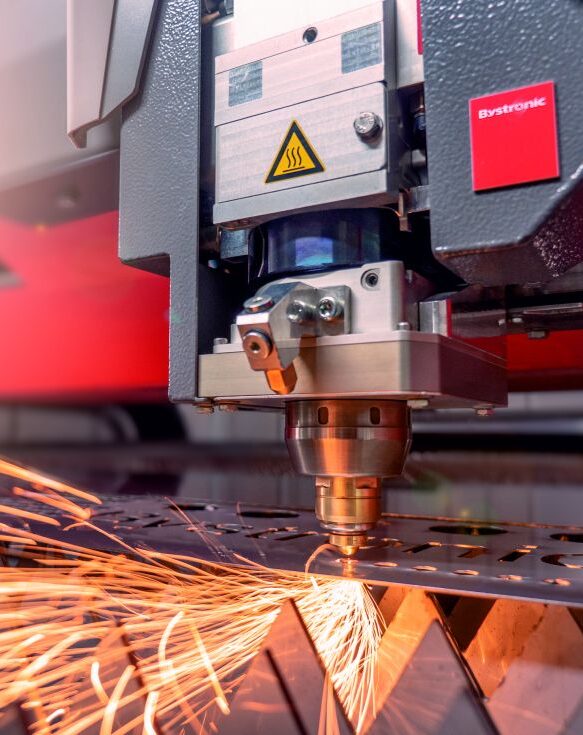 Ein Bystronic-Laserschneidkopf schneidet präzise ein Metallblech unter sprühendem Funkenflug.