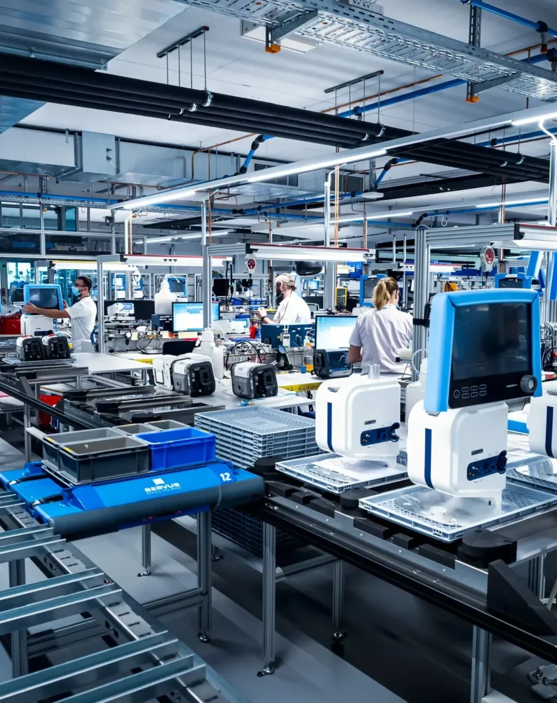 Mitarbeiter arbeiten an einer automatisierten Fertigungsstraße zur Herstellung von medizinischen Geräten.