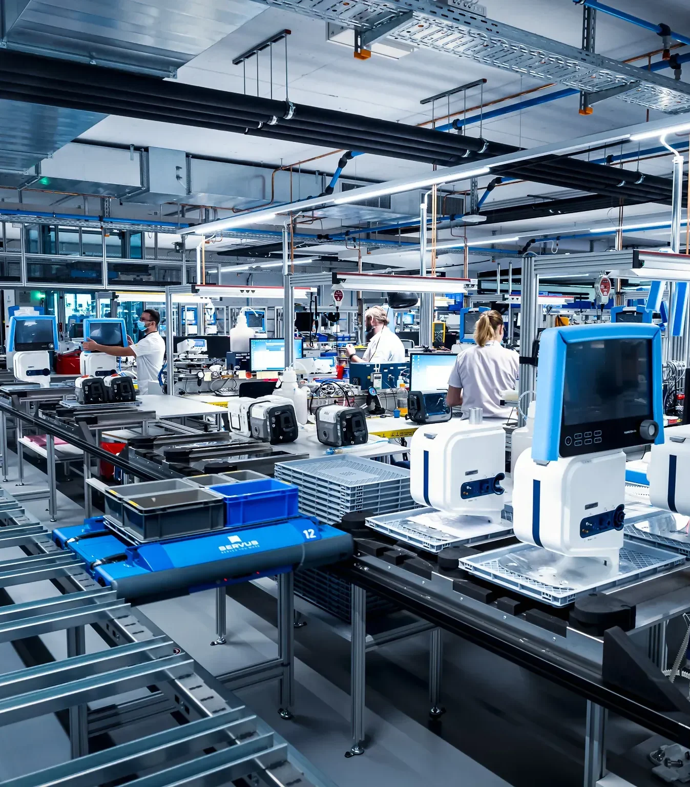 Mitarbeiter arbeiten an einer automatisierten Fertigungsstraße zur Herstellung von medizinischen Geräten.