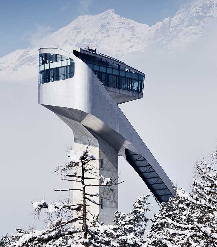 Die futuristische Bergisel-Skisprungschanze in Innsbruck vor einer verschneiten Bergkulisse im Winter.