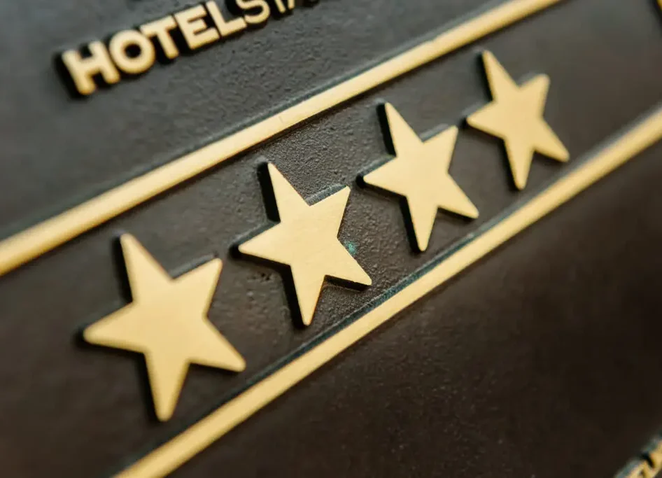 Vier goldene Sterne auf einer dunklen Hotel-Klassifizierungsplakette aus Metall.