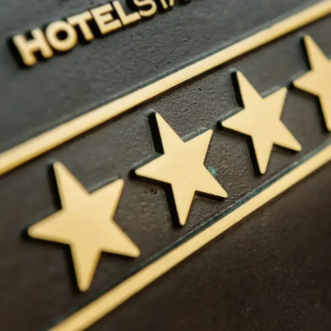 Goldene erhabene Sterne auf einer dunklen Metallplakette zur Hotelklassifizierung.